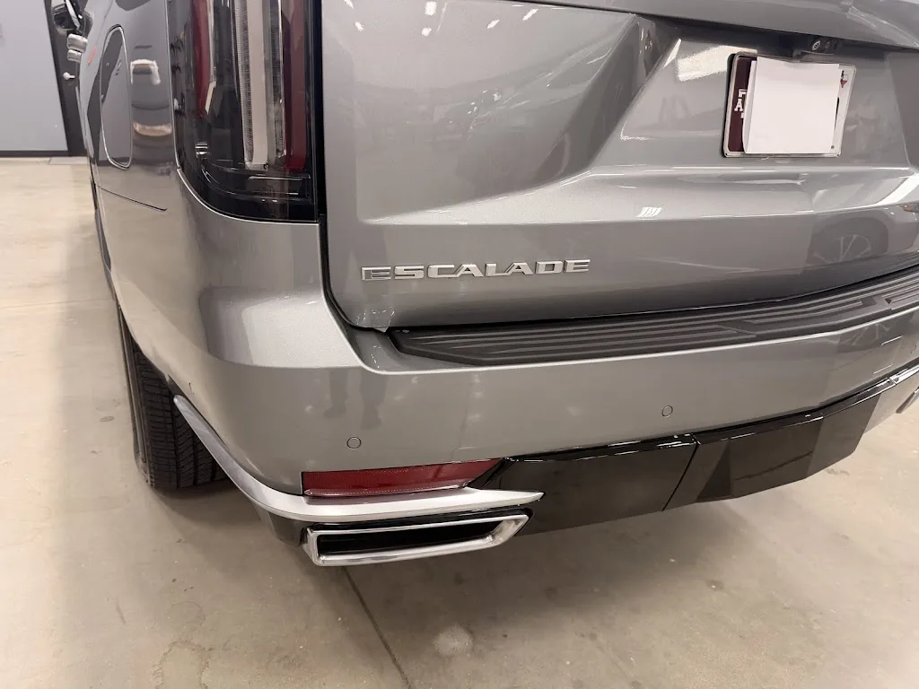 The same silver Cadillac Escalade after repair at Luxury Auto Body, rear quarter panel and bumper straight and refinished with the tail lamp replaced
