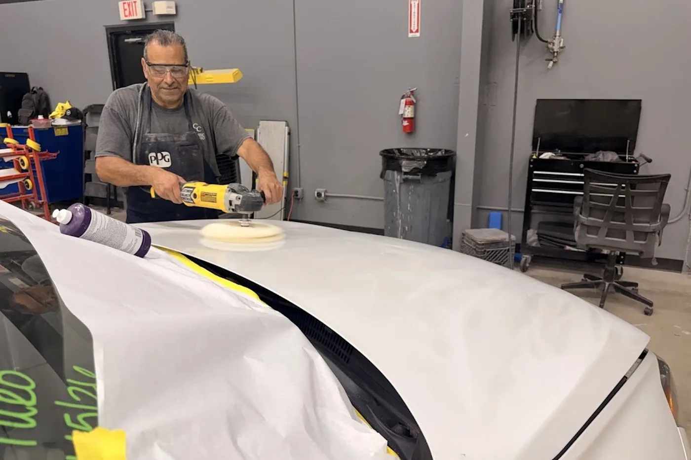 A Luxury Auto Body technician polishing a freshly refinished hood